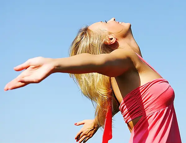 Woman standing outdoors with outstretched arms 